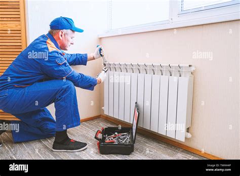 Male Plumber Fixes A Leak The Adjustable Wrench Tighten The Nut Clamps